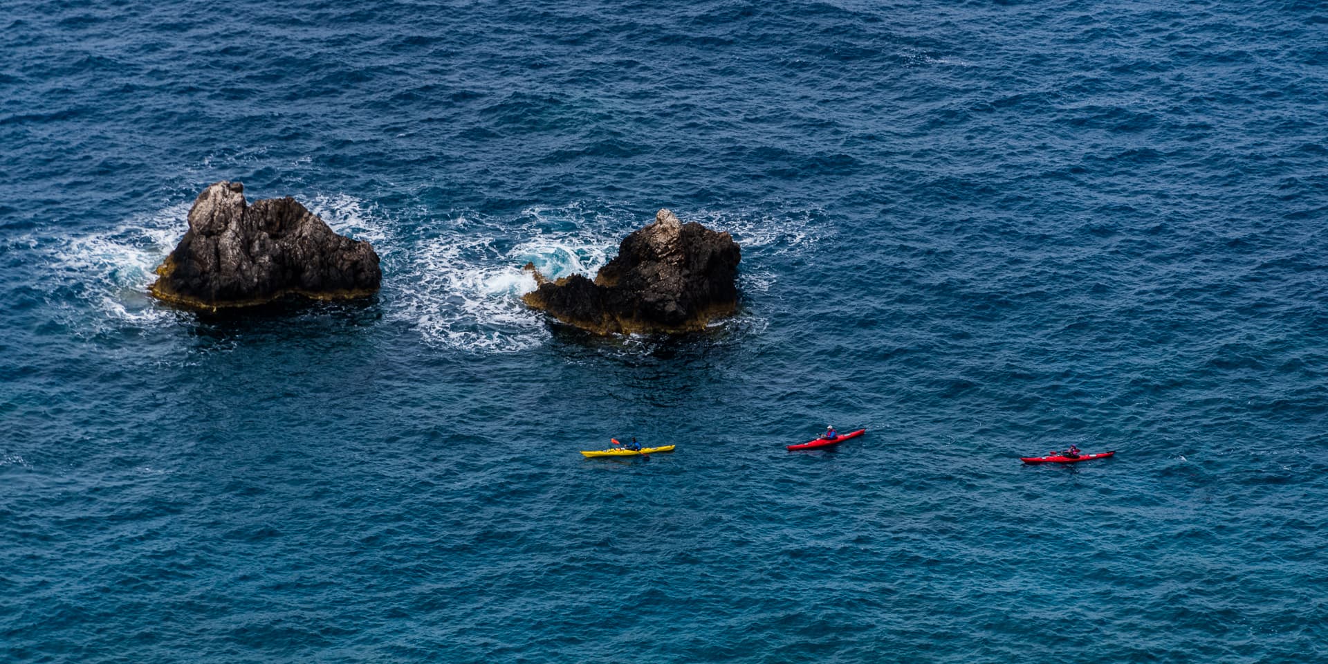 Sea kayaks in line, off the Messinian coast